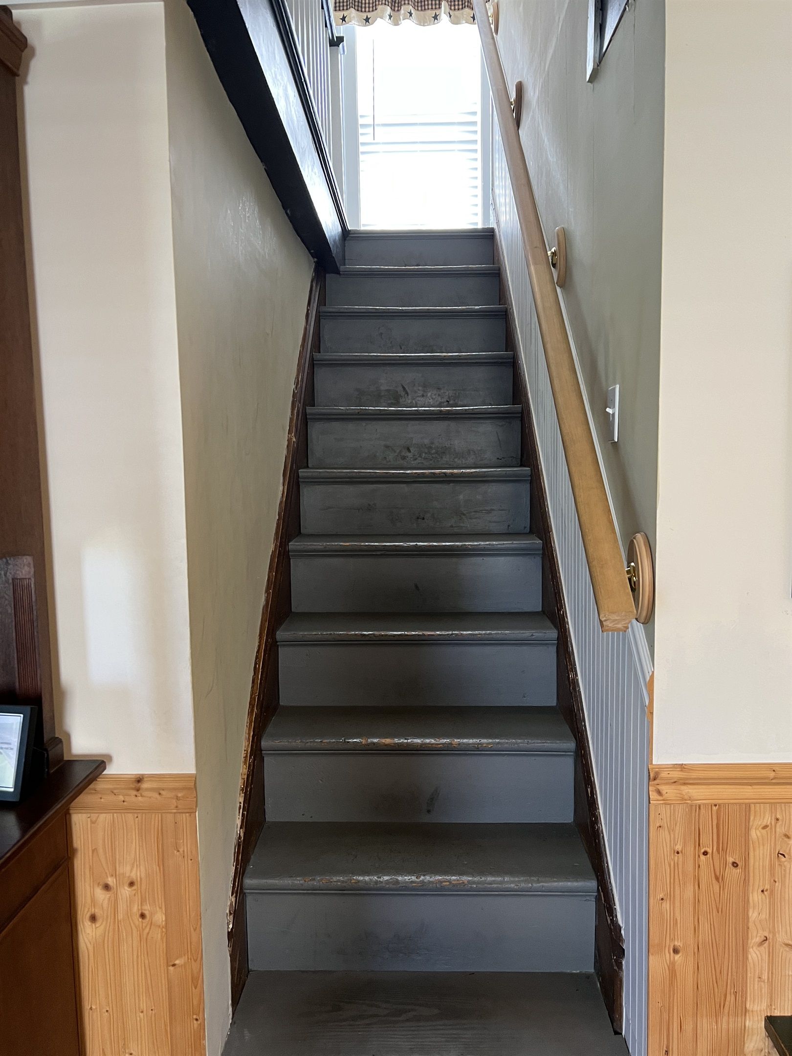 Un escalier avec des rampes en bois et une vue sur l’étage supérieur.