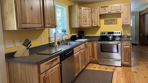 Una cocina con armarios de madera, electrodomésticos de acero inoxidable y un ventanal con vistas.