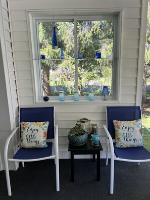 A porch with two white chairs and a small table, decorated with blue cushions and a potted plant. - Nelson House -  Pool, game room, basketball court, near All Star Village (Oneonta)