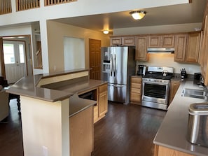 A modern kitchen with wooden cabinets, stainless steel appliances, and a central island.