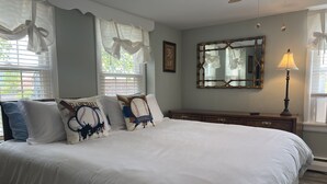 Quarto com uma cama grande, penteadeira, espelho e abajur.