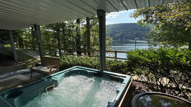 A hot tub under a covered patio with a view of a lake and hills. - Sunset Waters -Goodyear Lake - hot tub, swimming ,fishing. paddle sports (Maryland)