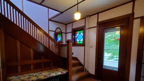 Una escalera con barandilla de madera y un banco con cojín floral.