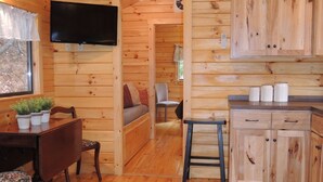 Ein Holzblockhaus-Innenraum mit Essbereich, Küche und gemütlichem Wohnbereich.