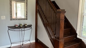 Un escalier avec des rampes en bois et une finition en bois foncé, menant à l’étage supérieur.