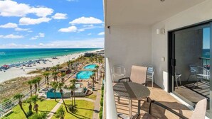 Ein Balkon mit Blick auf Strand und Poolbereich.