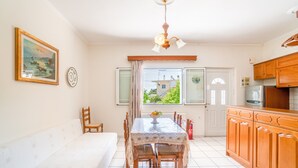 Comedor con una mesa, sillas, ventilador de techo y vista por una ventana.