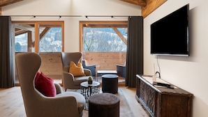 A modern interior with a wooden ceiling, a flat-screen TV, and a seating area with a sofa and chairs. - Apartment 'Alpin Chalet Samer Fürstenblick' with Mountain View, Terrace and Wi-Fi (Sarntal)