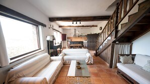 Una stanza accogliente con un divano, un tavolo in legno e una scala.