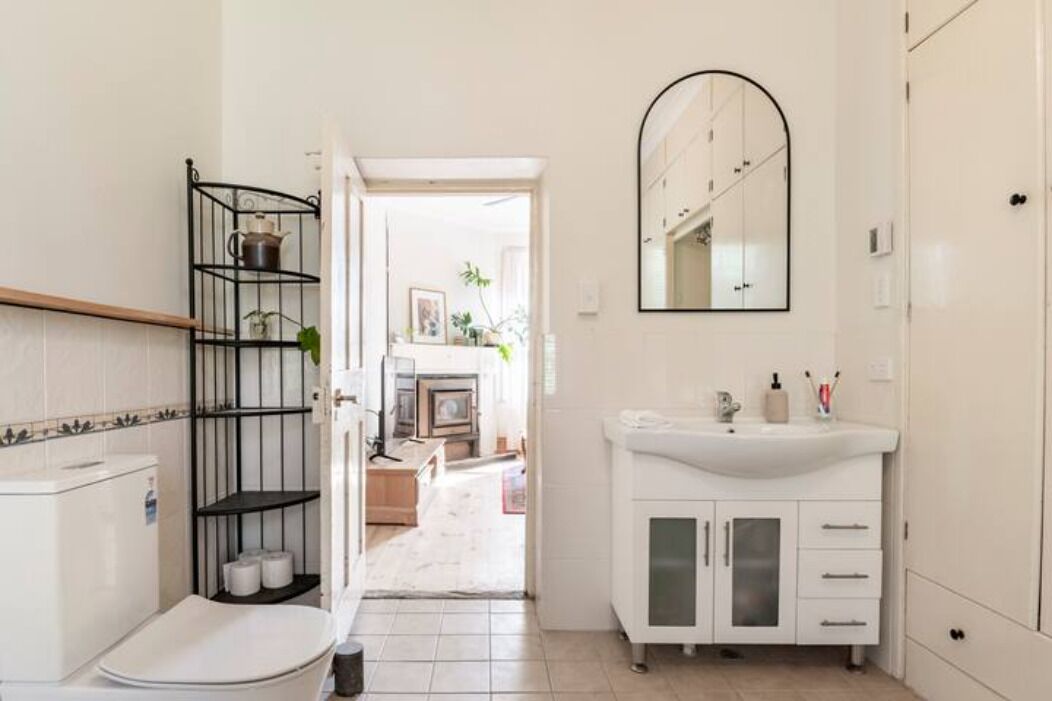 Un baño moderno con inodoro, lavabo y estantes.
