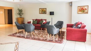 A modern living room with a red sofa, grey armchairs, and a patterned rug. - Perła Świeradowa (Swieradow-Zdroj)