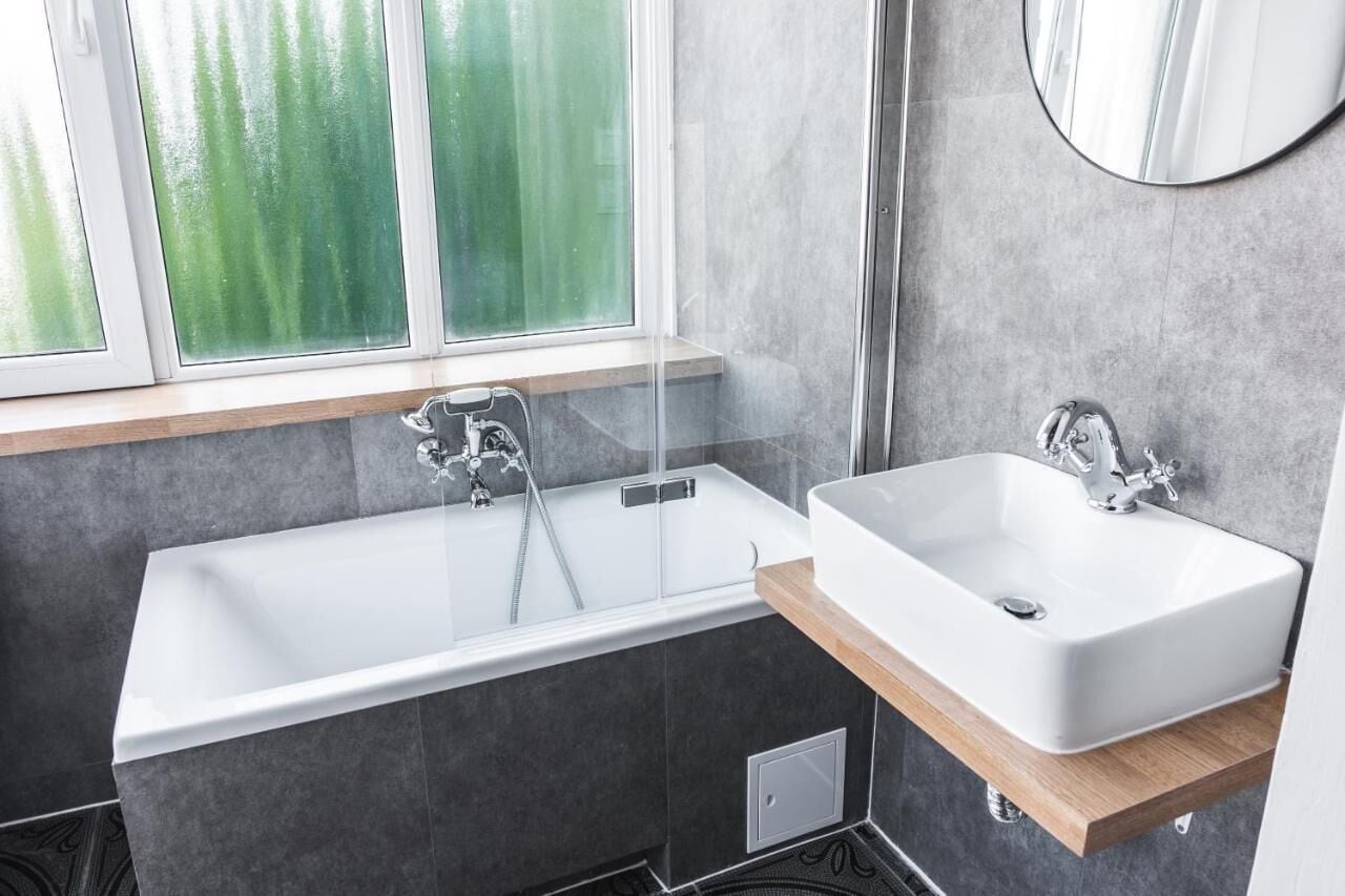 Ein modernes Badezimmer mit einer Badewanne, einem Waschbecken und einem Fenster.