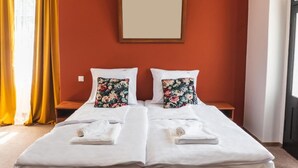 A double bed with floral pillows, a wooden nightstand, and a framed mirror on the wall. - Perła Świeradowa (Swieradow-Zdroj)