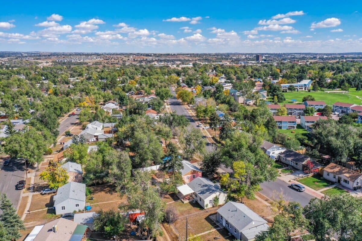 An aerial view of a residential area with houses, roads, and greenery.