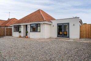 A modern house with a tiled roof, a gravel driveway, and a wooden fence. - Little Soames, Holt, Norfolk (Holt)