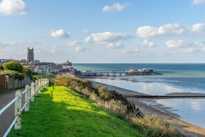 A coastal town with a prominent church, a pier, and a grassy promenade. - Little Soames, Holt, Norfolk (Holt)