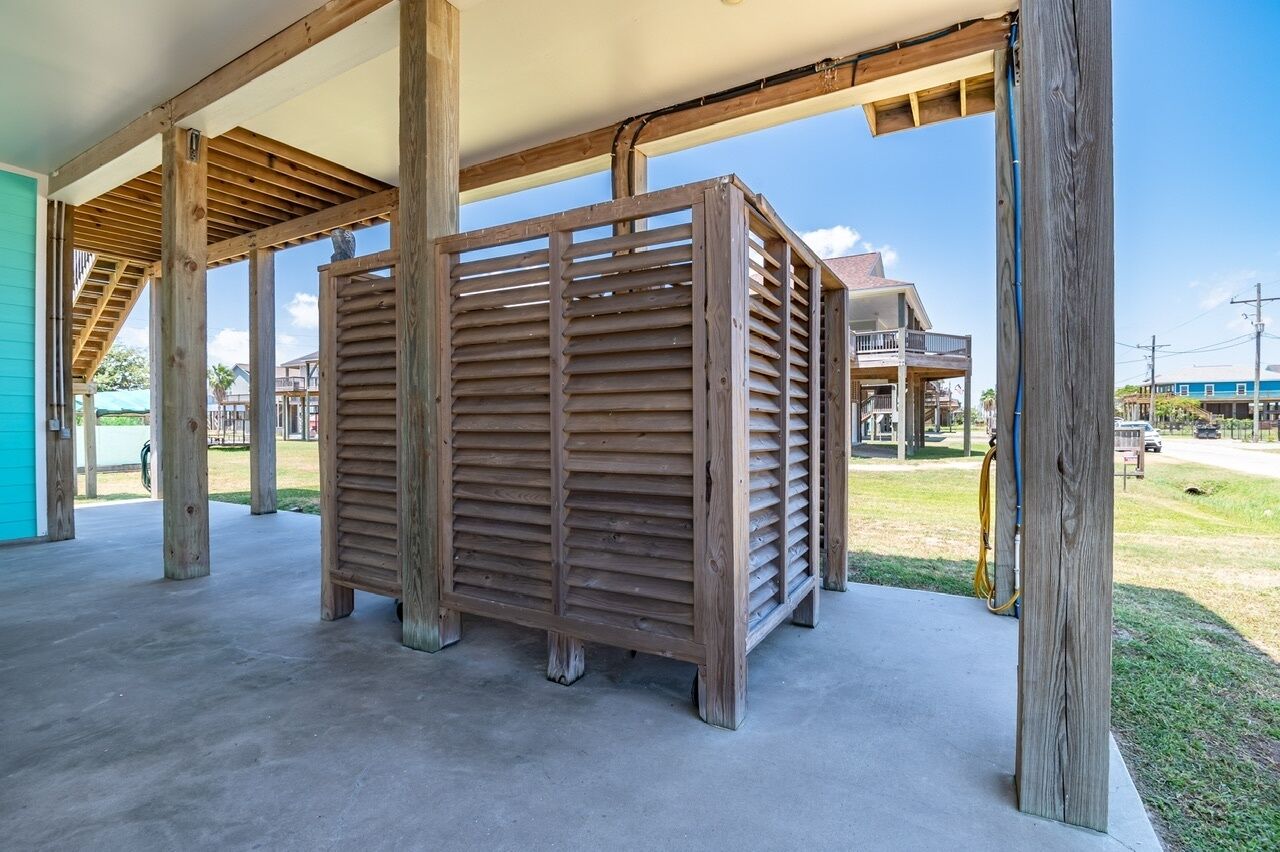 A covered outdoor area with a wooden structure and concrete floor.
