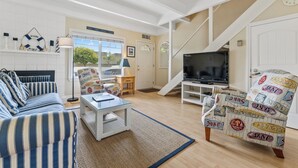 A living room with a sofa, armchair, TV, and a staircase. - Sunny Rio Del Mar Beach Townhome – Relax, Unwind & Enjoy the Coast (Aptos)