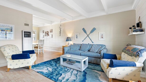 A living room with a striped sofa, armchairs, a coffee table, and a blue rug. - Sunny Rio Del Mar Beach Townhome – Relax, Unwind & Enjoy the Coast (Aptos)