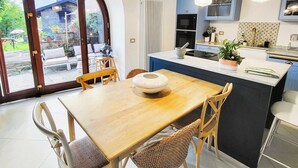 A modern kitchen with a central island, wooden chairs, and pendant lighting. - Beautifully converted watermill with private pool and own waterfall! (San Romano in Garfagnana)