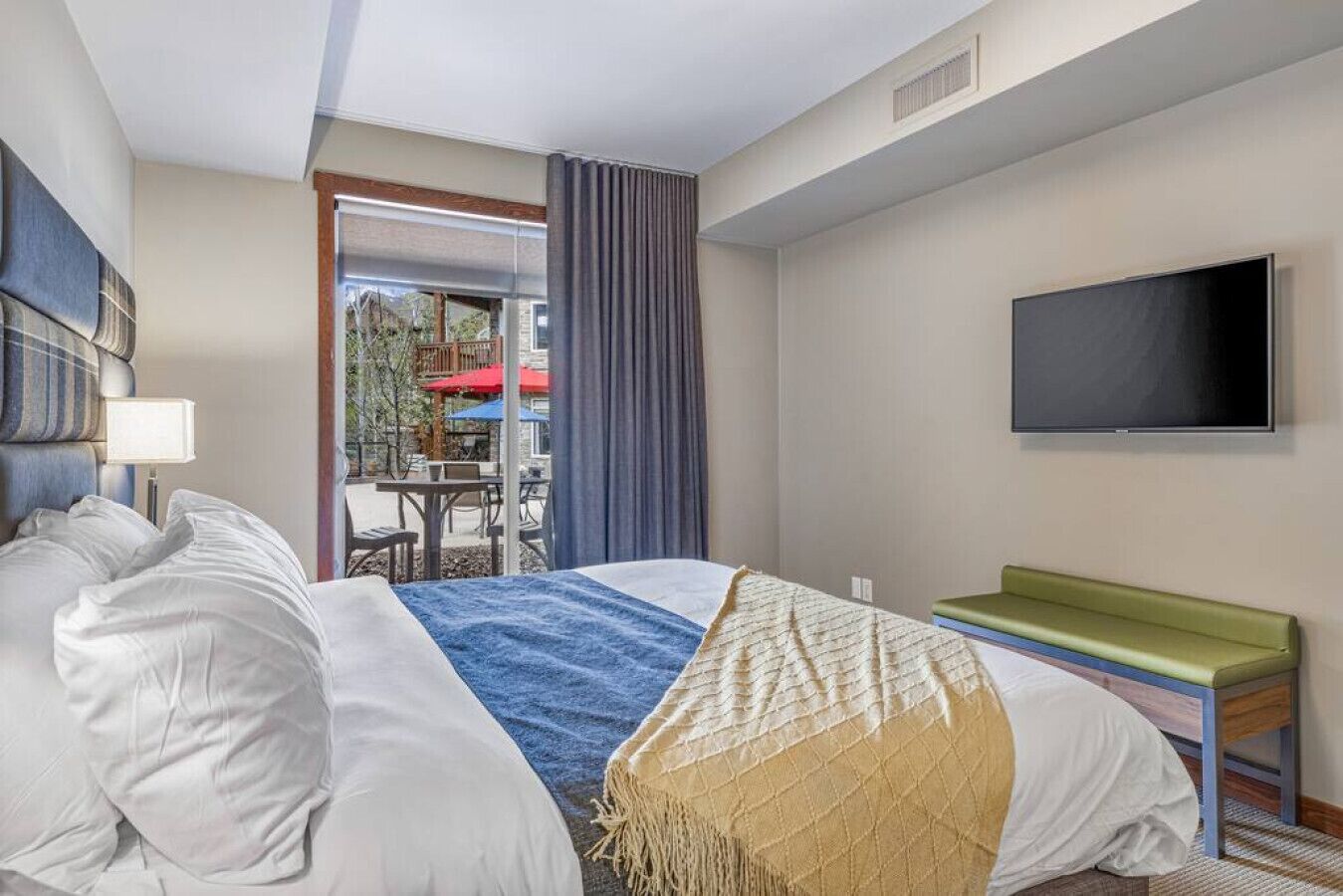 Une chambre d’hôtel avec un lit, une télévision, une fenêtre avec des rideaux et une vue sur l’extérieur.