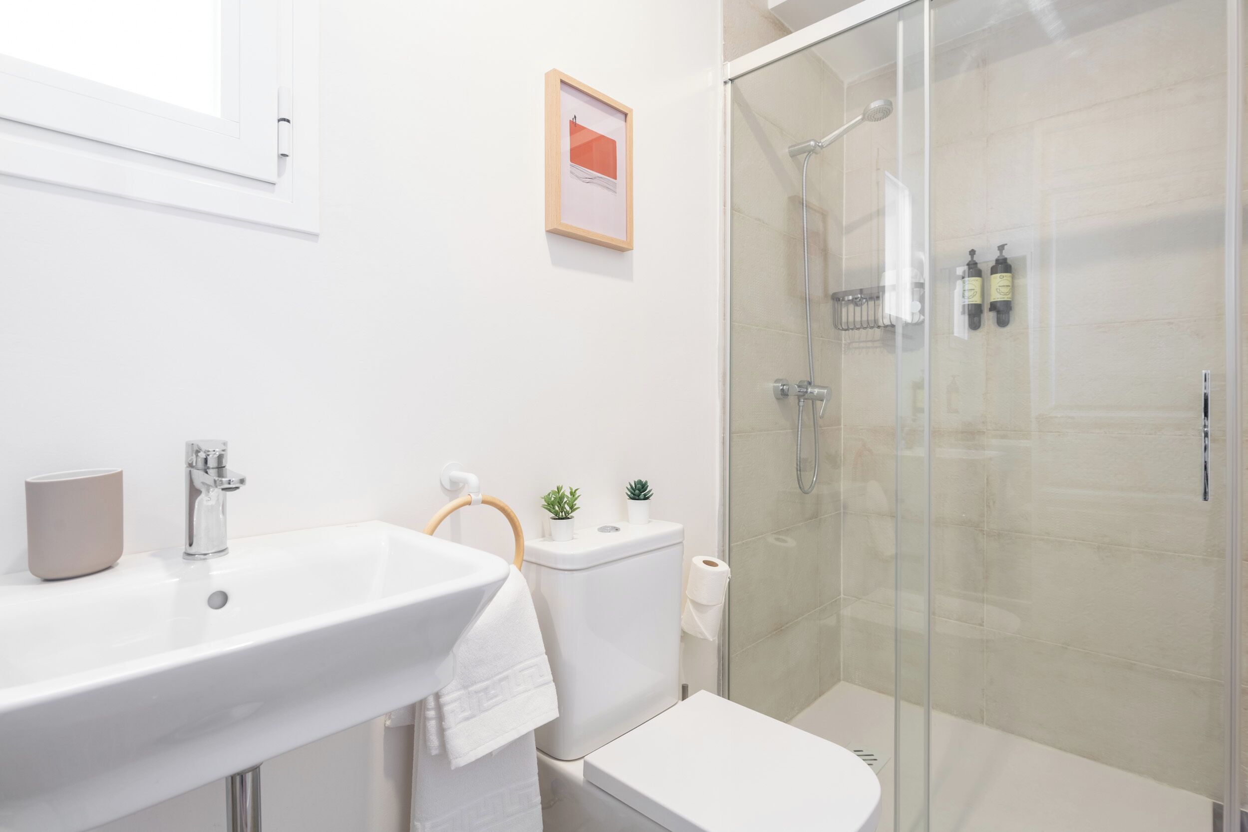 Ein modernes Badezimmer mit Waschbecken, Toilette und Duschkabine aus Glas.