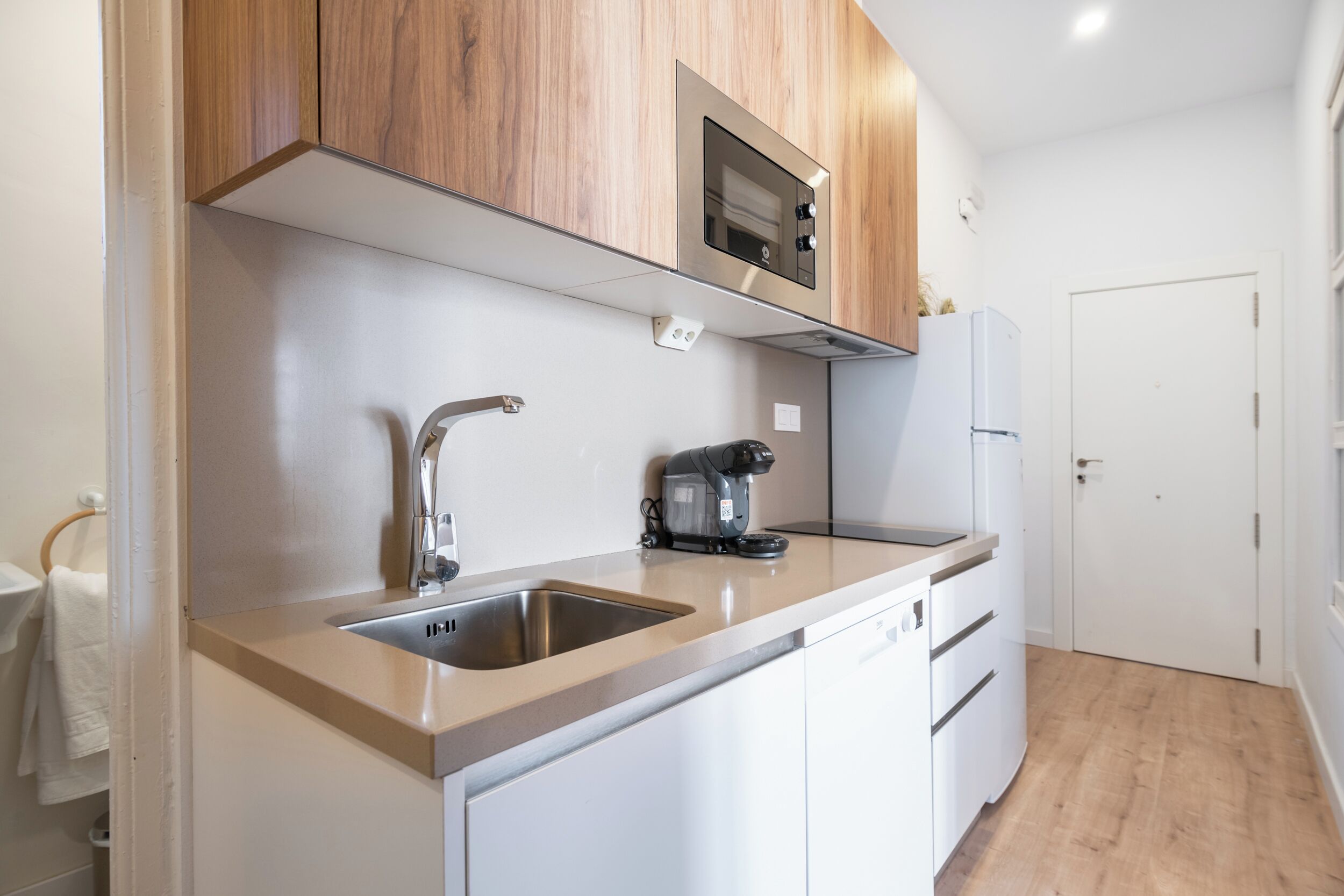 A modern kitchen with stainless steel appliances, a built-in oven, and a coffee maker.