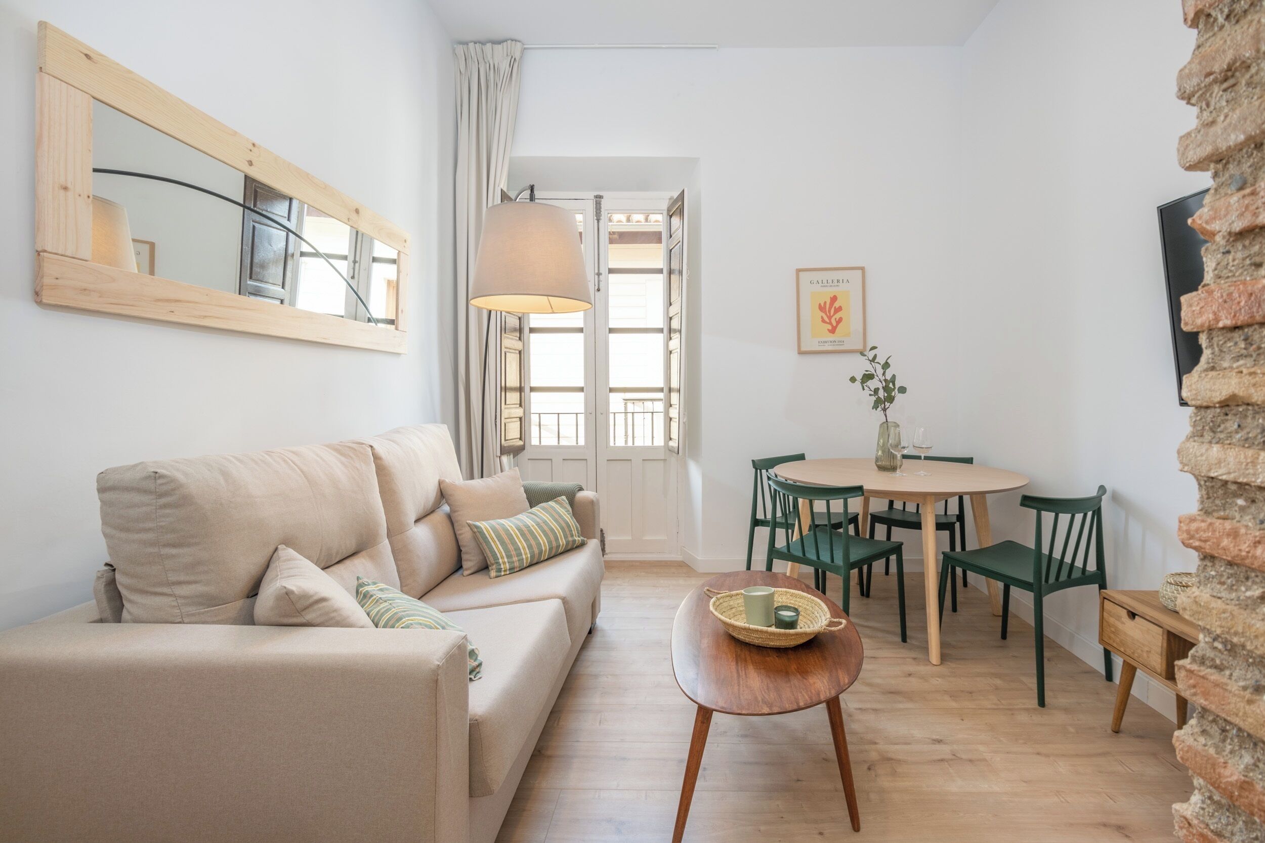 A cozy living room with a sofa, a wooden coffee table, and a dining area with chairs and a table.