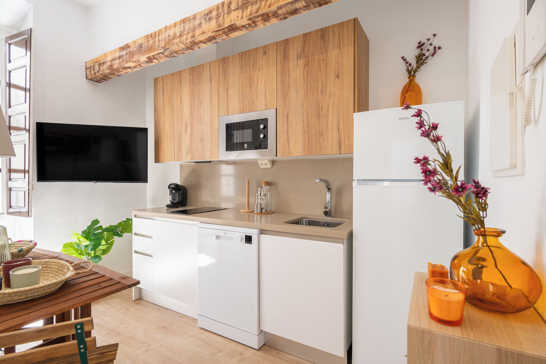 A modern kitchen with wooden cabinets, a microwave, a dishwasher, and a refrigerator.