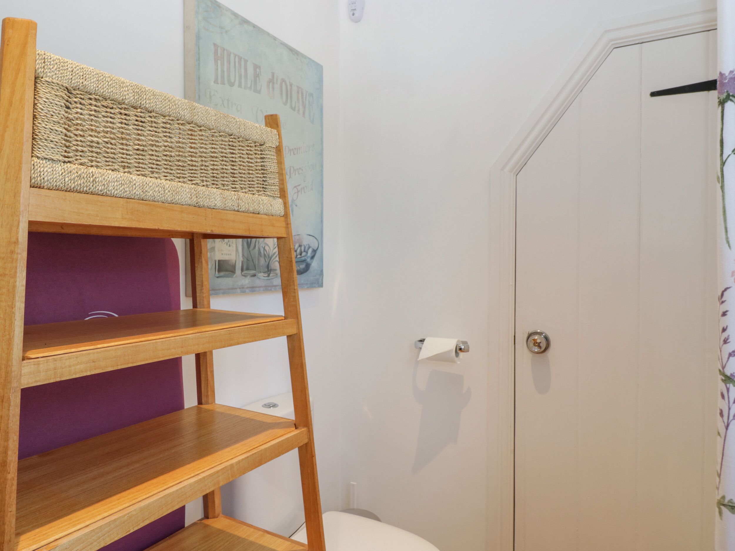 Una cama litera con un cabecero tejido, una puerta con cerradura y un cartel en la pared.