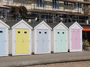 A row of colorful beach huts with doors numbered 1 to 4.