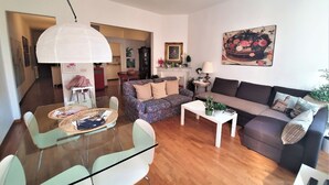 A modern living room with a sofa, a coffee table, and a dining area with chairs and a table. - In Florence, in the heart of dowtown (Firenze)