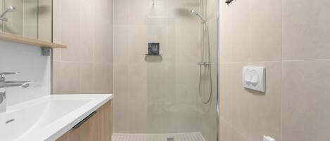 Un baño moderno con ducha, inodoro y lavamanos.