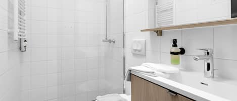 Un baño moderno con ducha, inodoro y lavamanos.