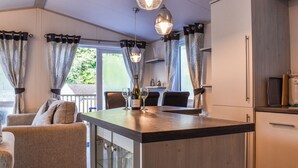 Une cuisine moderne dotée d’un îlot central, d’un coin repas avec des chaises et d’un canapé.