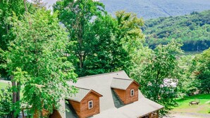 Une cabane en bois avec une véranda et une voiture garée devant.