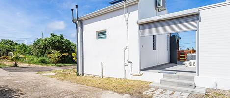 Un edificio moderno con una puerta de garaje, un tanque de agua en el techo y una ventana pequeña.