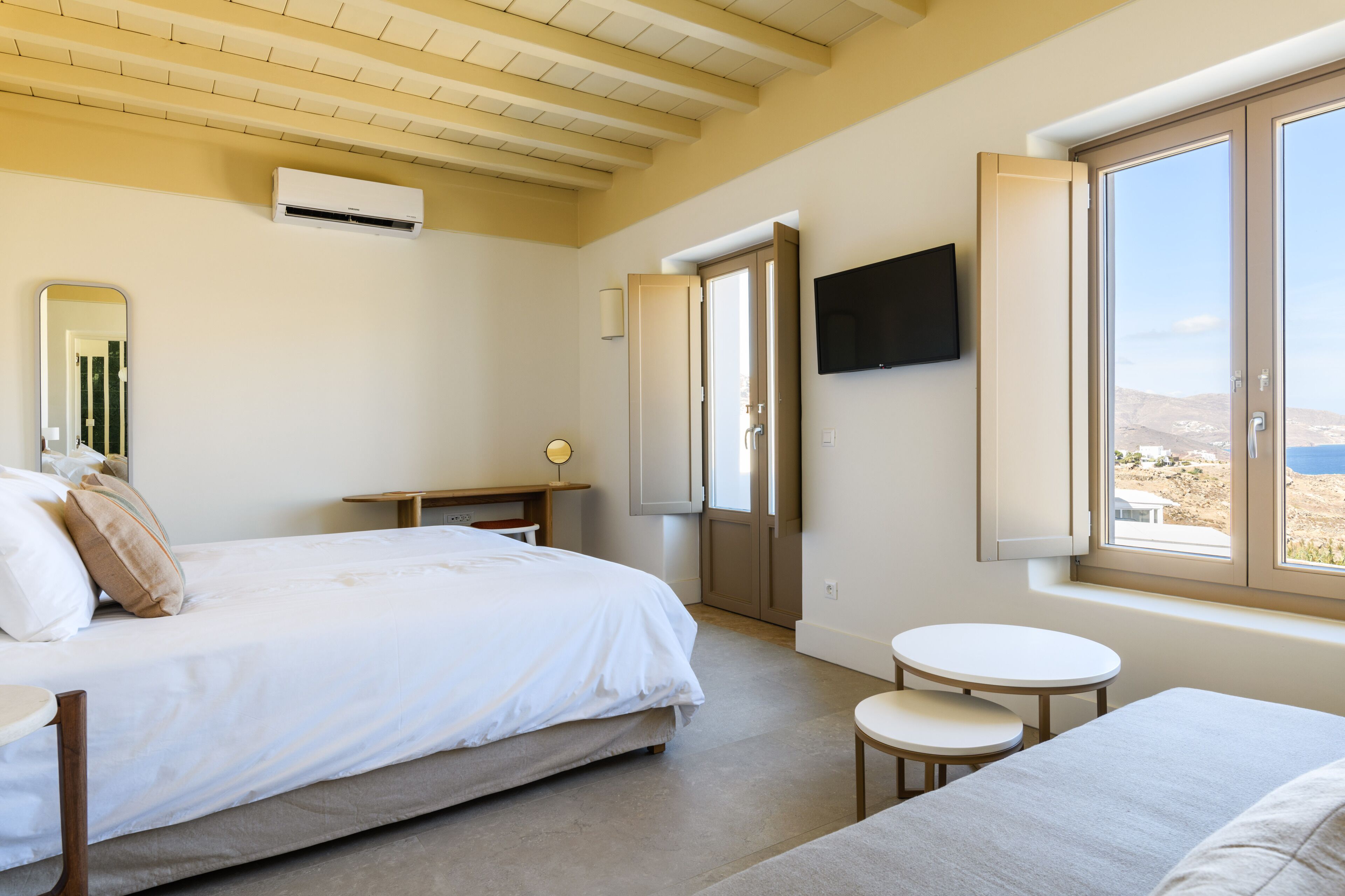 Ein Schlafzimmer mit Bett, Nachttisch und einem an der Wand befestigten Fernseher.
