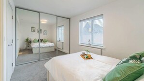 A bedroom with a bed, a window, a radiator, and a sliding door. - 4BR-Madejski Stadium-Royal Berk Hosp-By Tempstay (Reading)