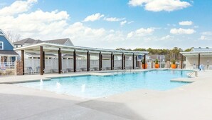 Une piscine dotée d’un espace détente abrité, d’une terrasse clôturée et d’un ciel dégagé.
