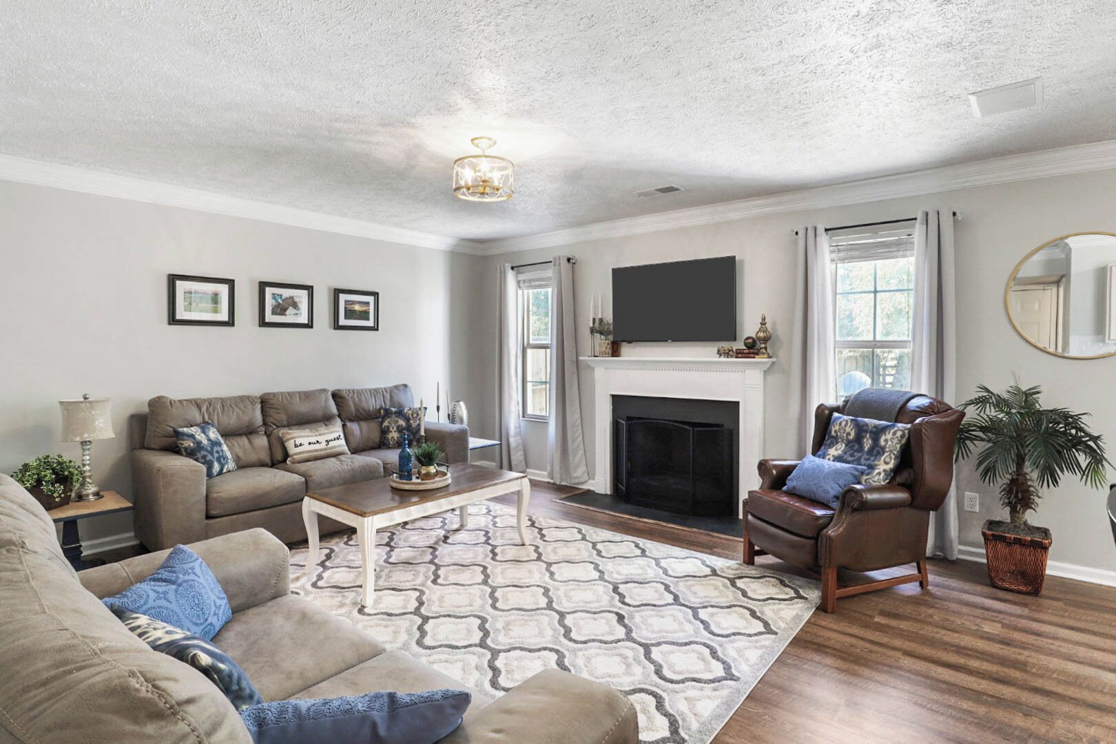 A living room with a fireplace, a sofa, a coffee table, and a chair.