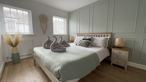 A bedroom with a bed, bedside tables, and a radiator. - Harbourside, Luxury Two Bedroom Townhouse with Bike store – Sleeps 6 (Wick)