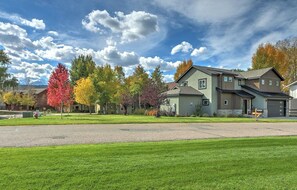 A residential area with houses, a clear sky, and autumn-colored trees.