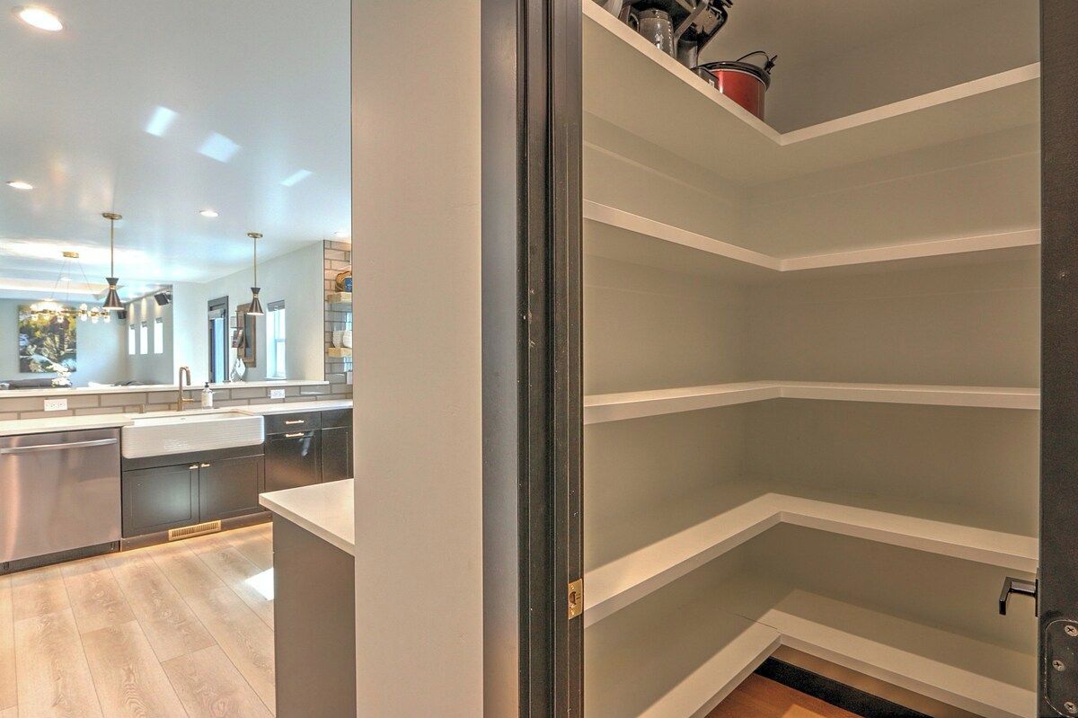 A modern kitchen with built-in appliances, a central island, and pendant lighting.
