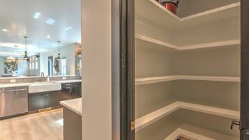 A modern kitchen with built-in appliances, a central island, and pendant lighting.