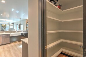 A modern kitchen with built-in appliances, a central island, and pendant lighting.