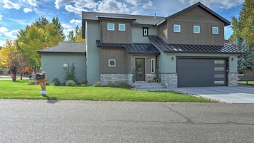 A two-story house with a garage, a front porch, and a mailbox.