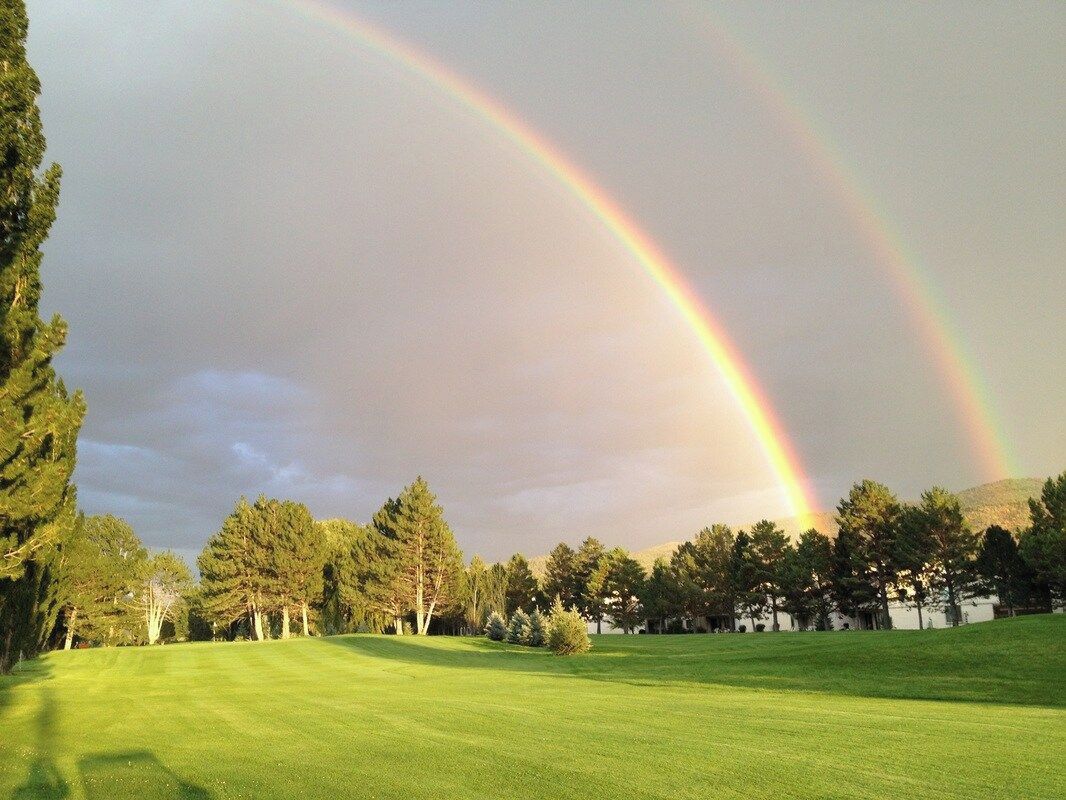 Un campo de golf con un arcoíris en el cielo.