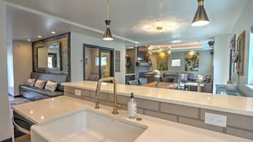 A modern kitchen with a large island, a built-in sink, and pendant lighting.