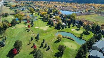 A golf course with multiple holes, water hazards, and surrounding trees.